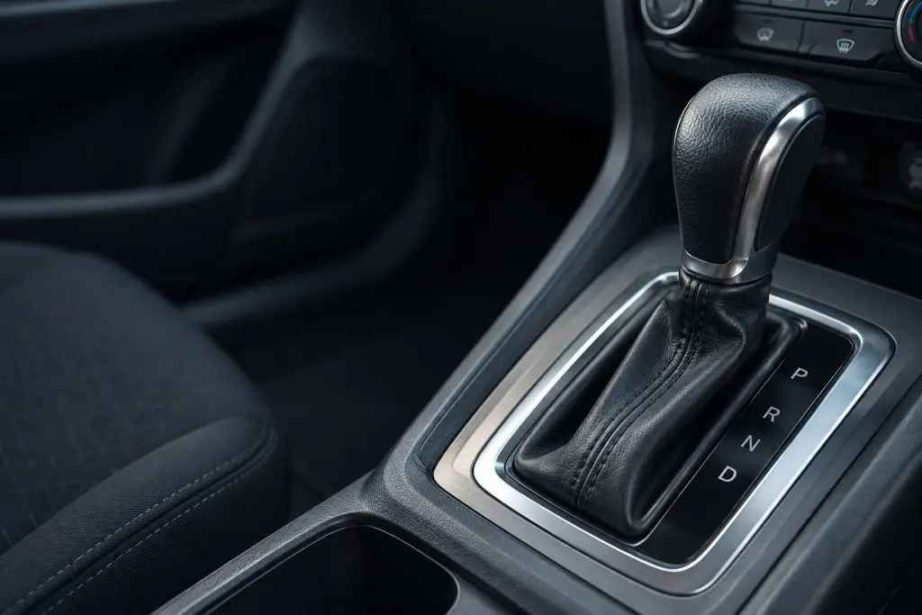Automatic gear selector beside Park, Reverse, Neutral and Drive markings inside a car.
